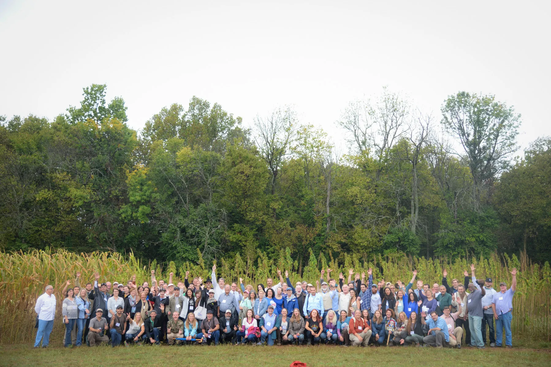 A large group of hemp industry members gathered in front of a Kentucky hemp field