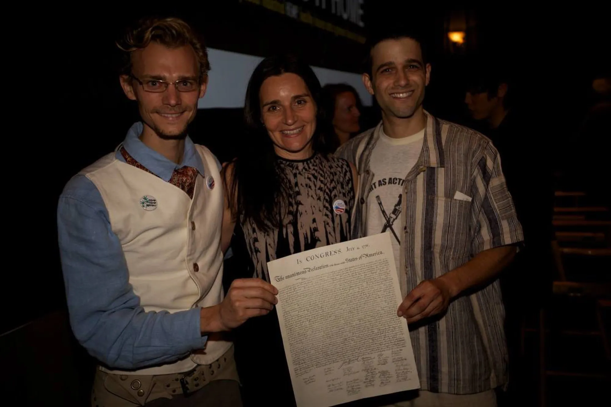Tyler Hemp with Christina Vulgesi and Eric Loitz holding a printed copy of the Declaration of Independence